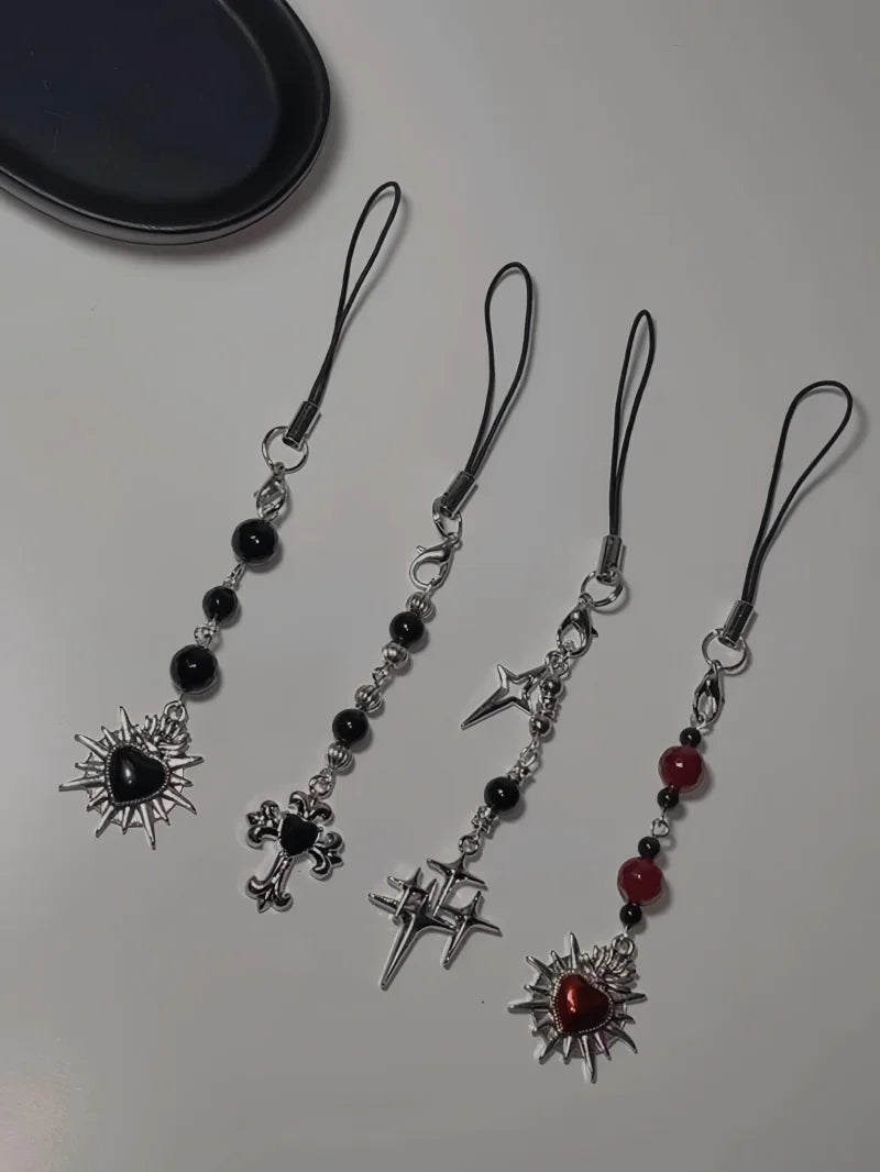 Four decorative phone straps with star and cross designs on a white surface.