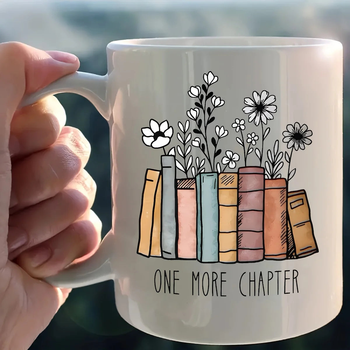 Floral ceramic mug featuring the phrase "Another Chapter" alongside an illustrated book design. A charming 320ml coffee cup for book lovers, readers and cosy reading nook decor