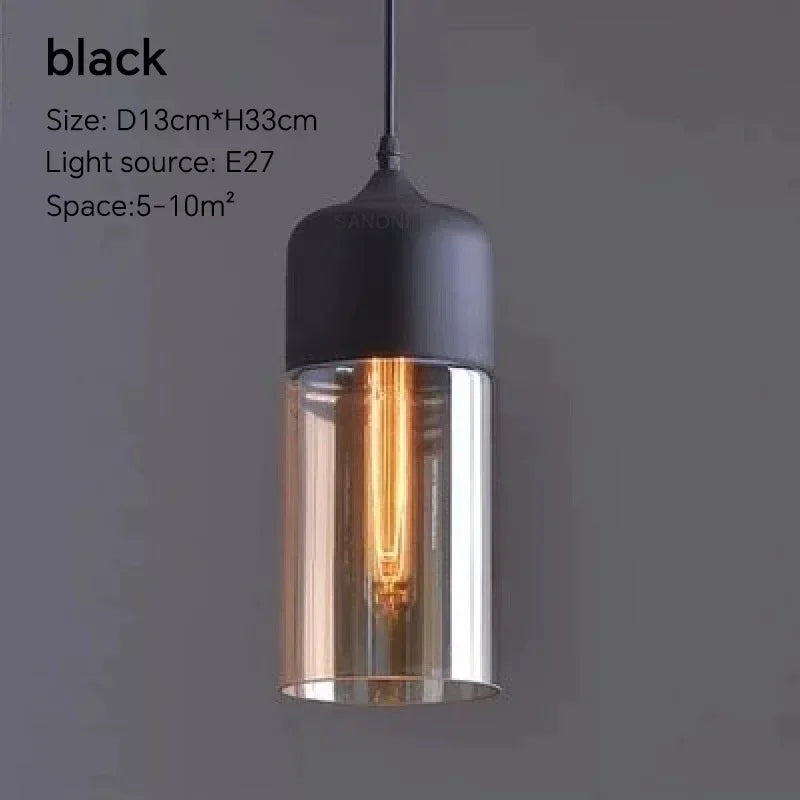 Black pendant light with clear glass shade on a dark background