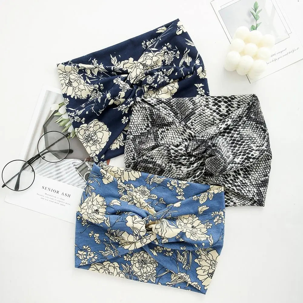 Three patterned headbands on a white surface with glasses and a magazine.