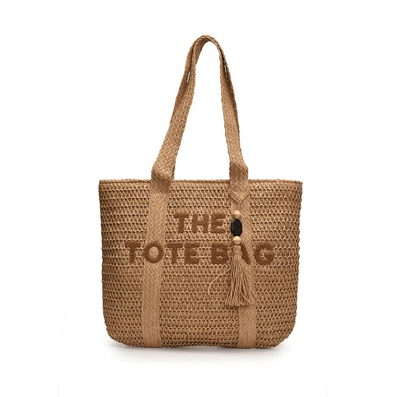Woven handbag with 'THE LOVE BAG' text and tassel on a white background