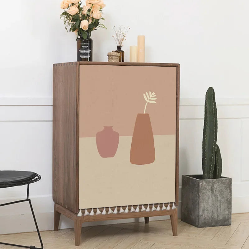 Wooden cabinet with decorative vase design on a beige background, next to a cactus plant.