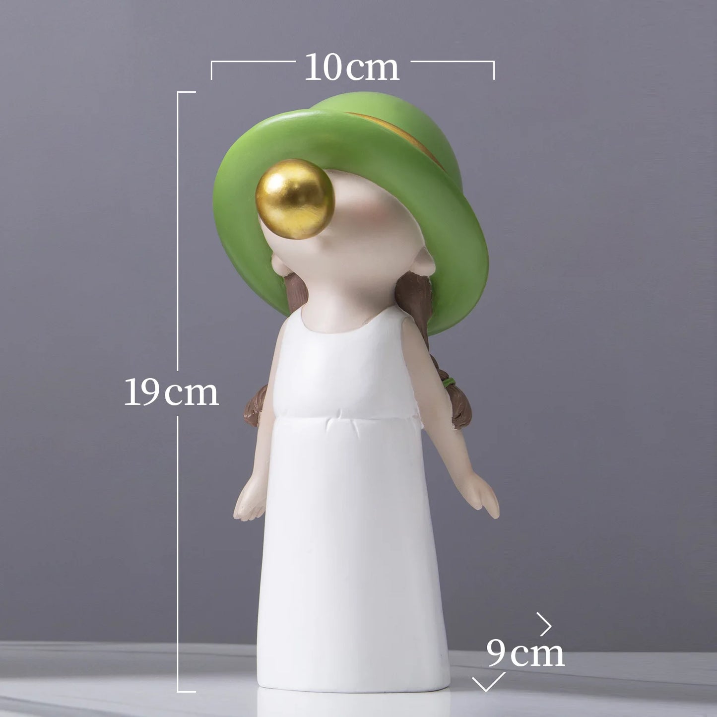 Decorative figure with a green hat and white dress, showing measurements on a gray background