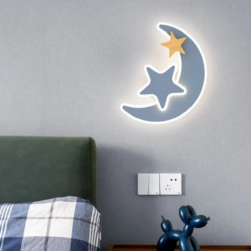 Neon moon and star wall light on a gray wall above a bed with plaid bedding.