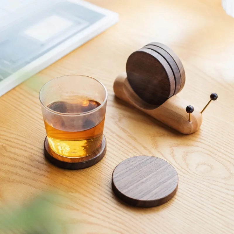 Wooden drink coaster set with a glass of amber liquid on a wooden surface.