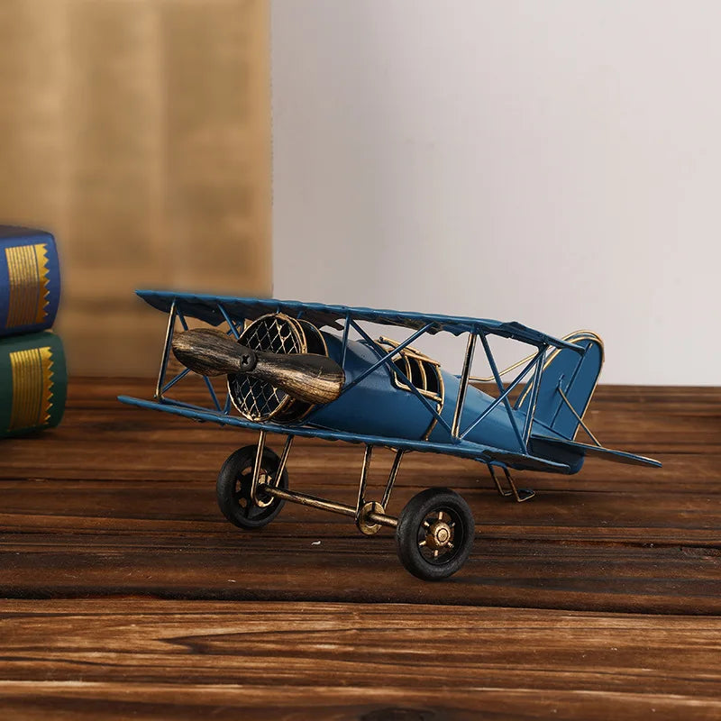 Vintage metal airplane ornament with a detailed retro aircraft design, available in red, yellow and blue for desk or shelf display.