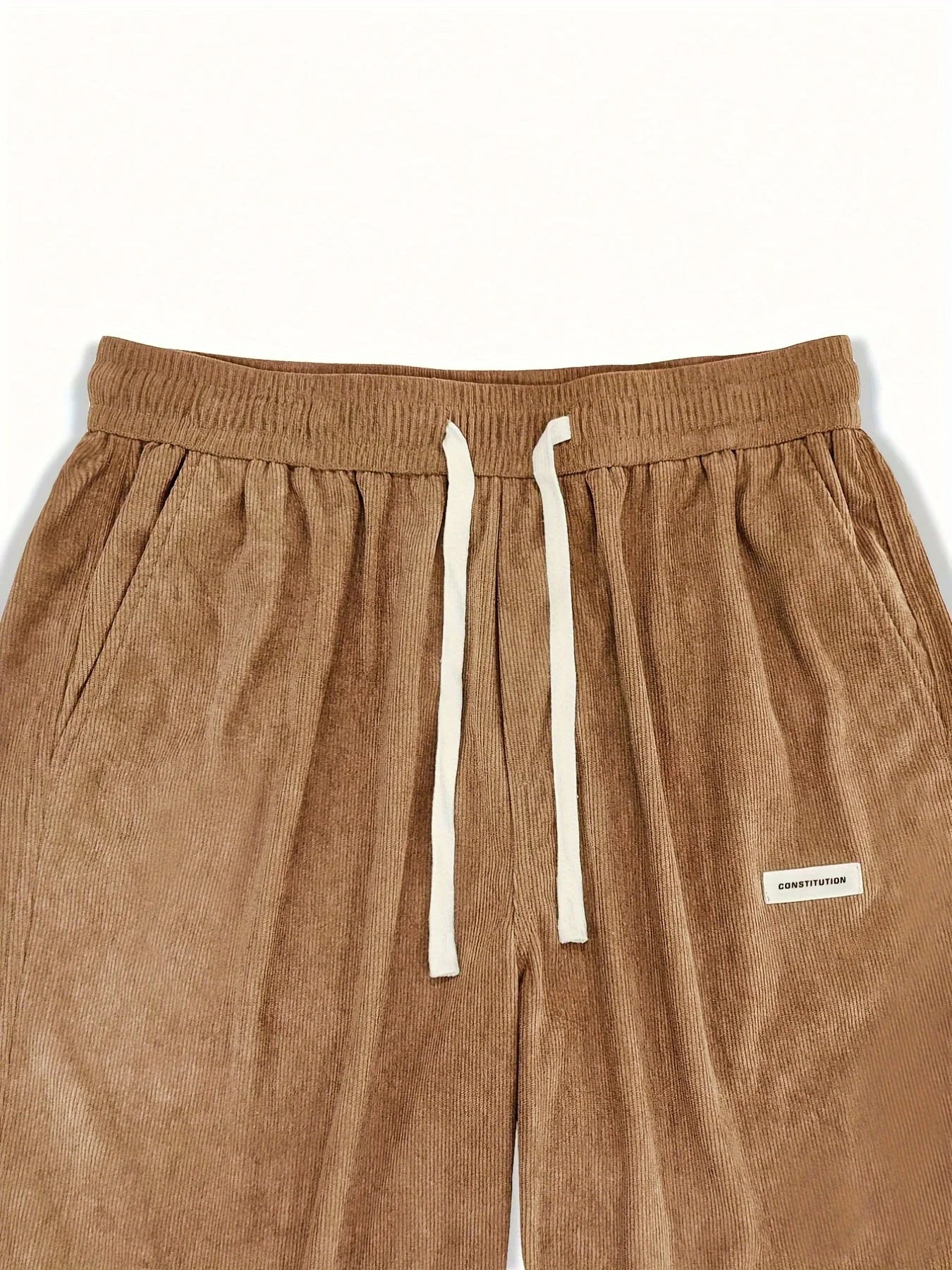 Brown corduroy pants with a drawstring on a white background