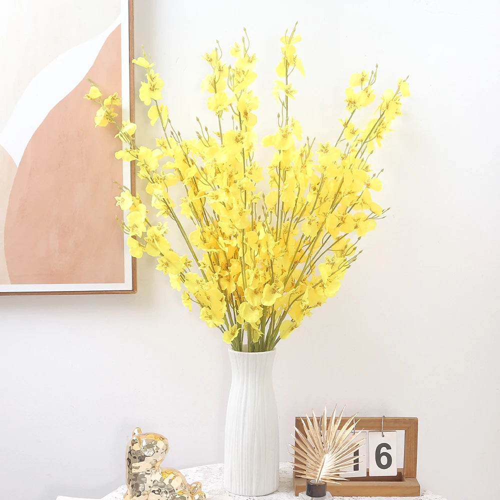 Yellow floral arrangement in a white vase on a table with a light background