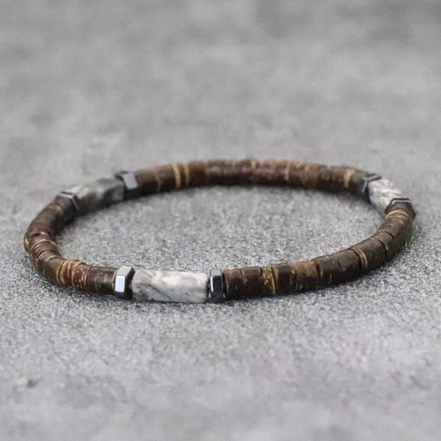 Bracelet with brown and silver beads on a gray surface