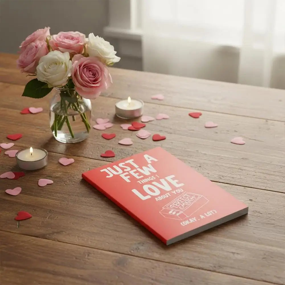 Red book titled 'Just a Few Things Love Does for You' on a wooden table with flowers and candles.