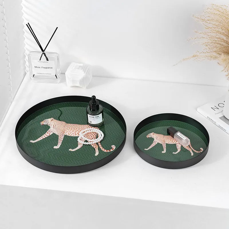 Two round decorative trays with leopard designs on a white surface.
