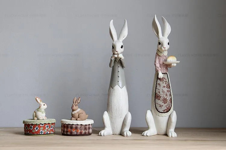 Set of ceramic rabbit figurines on a wooden surface with a gray background
