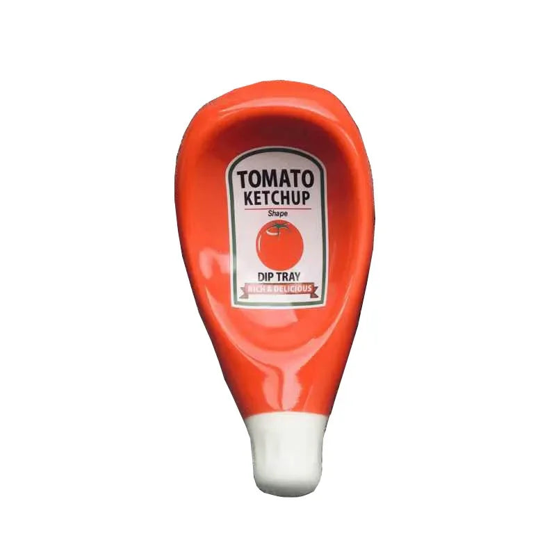 A novelty ketchup dip tray shaped like a squeeze bottle, featuring a glossy red body, a white cap, and a front label that reads 'TOMATO KETCHUP' with an orange graphic and 'DIP TRAY' below.