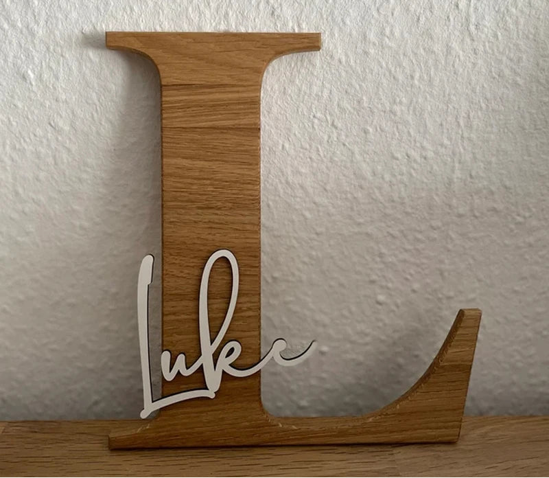 Wooden letter 'L' with the name 'Luke' on a white textured wall background