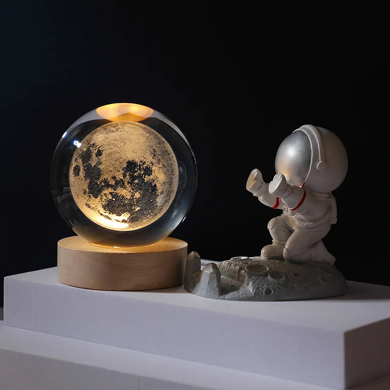 Decorative setup with a moon globe and astronaut figure on a dark background