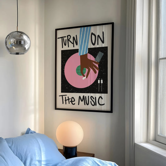 Framed artwork with 'Turn On The Music' text in a bedroom setting.