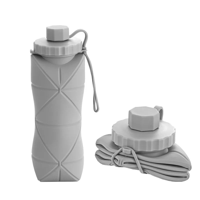 Collapsible gray silicone water bottle with carrying strap on a white background