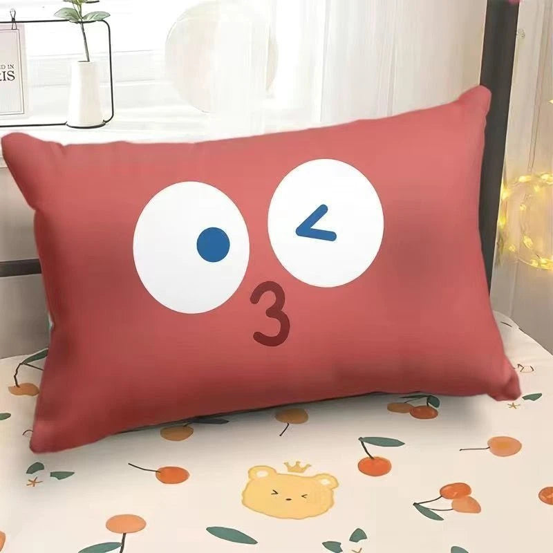 Red pillow with cartoon face on a bed with a floral pattern