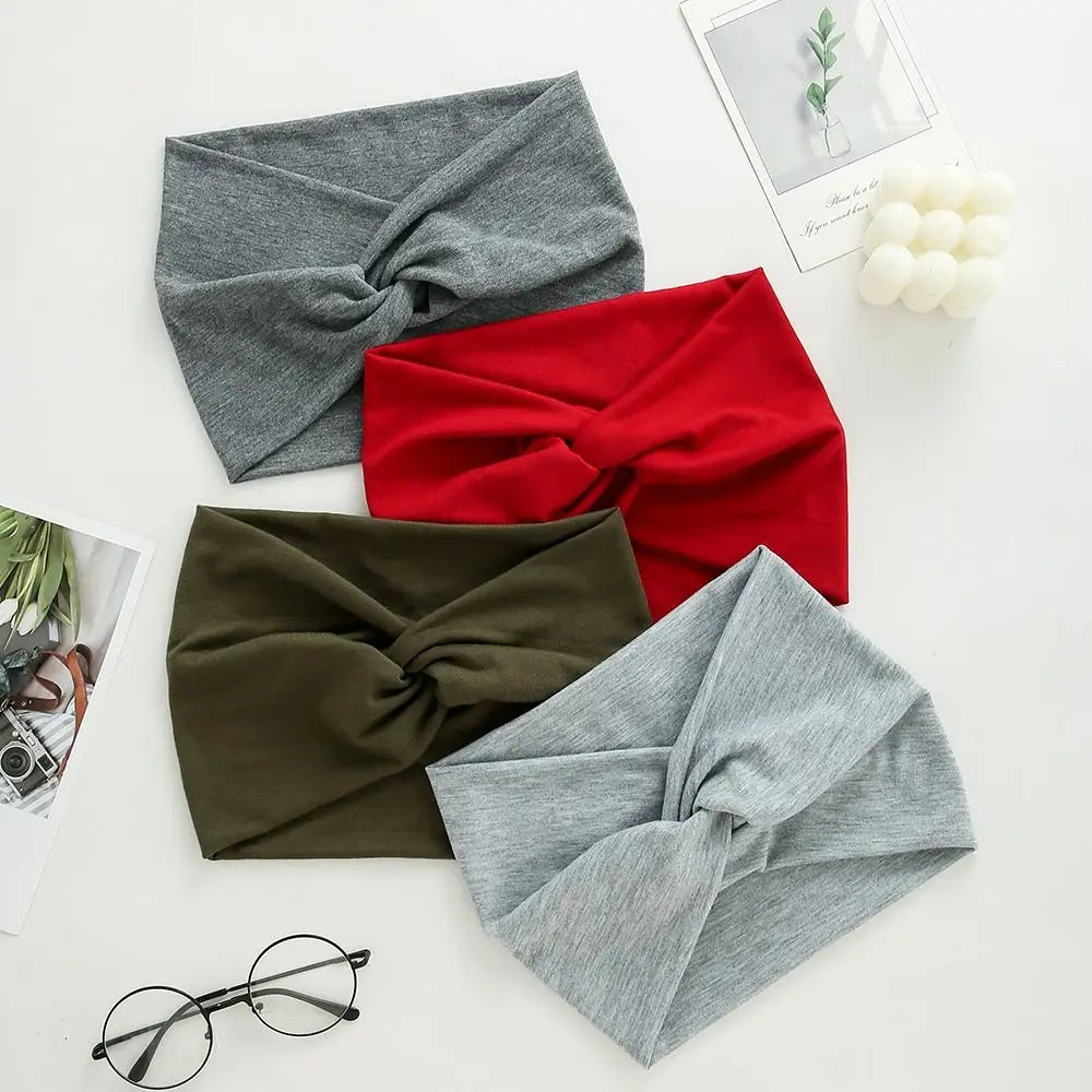 Four headbands in gray, red, green, and gray on a light surface with glasses and photos.