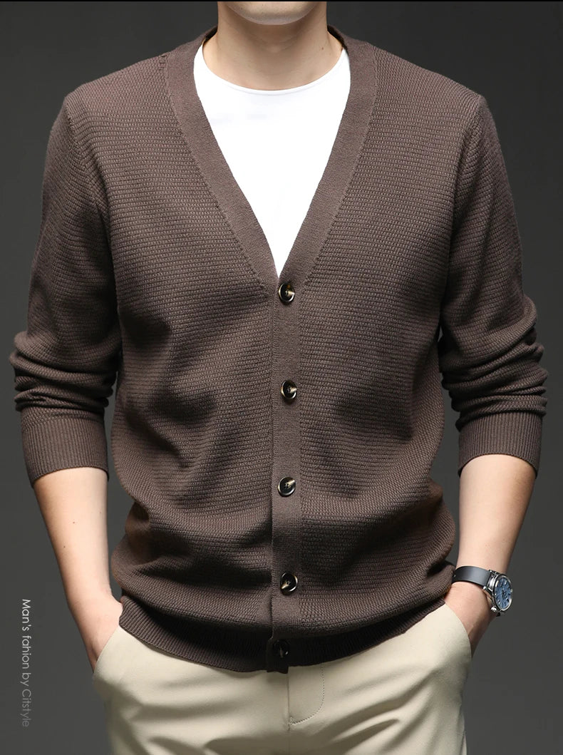 Brown cardigan worn by a person on a dark background