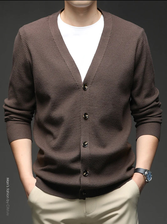 Brown cardigan worn by a person on a dark background