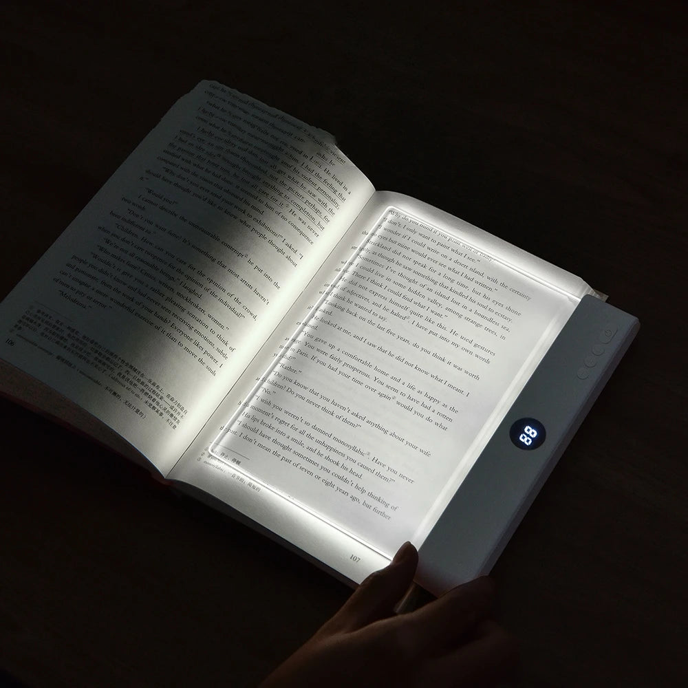 Open book with a light illuminating the text in a dark setting