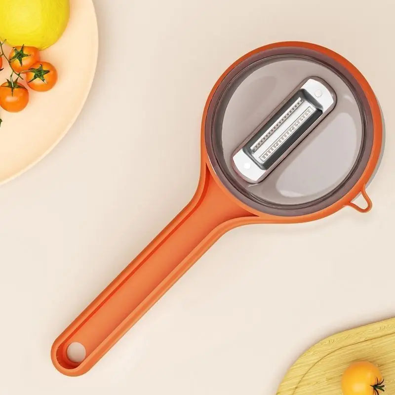 Orange vegetable peeler on a beige background with tomatoes and lemons.