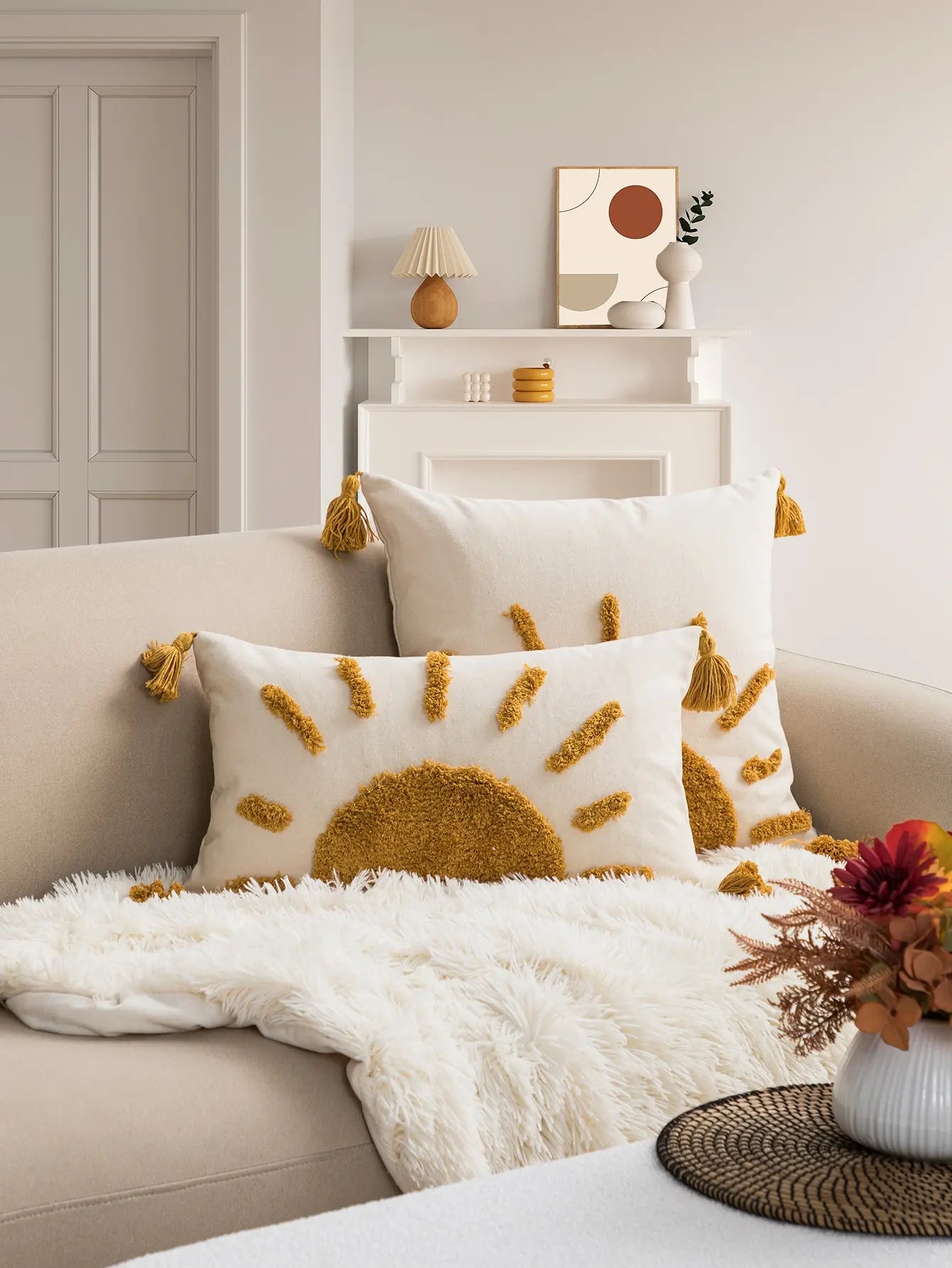 Decorative pillow with sun design on a sofa in a living room setting.