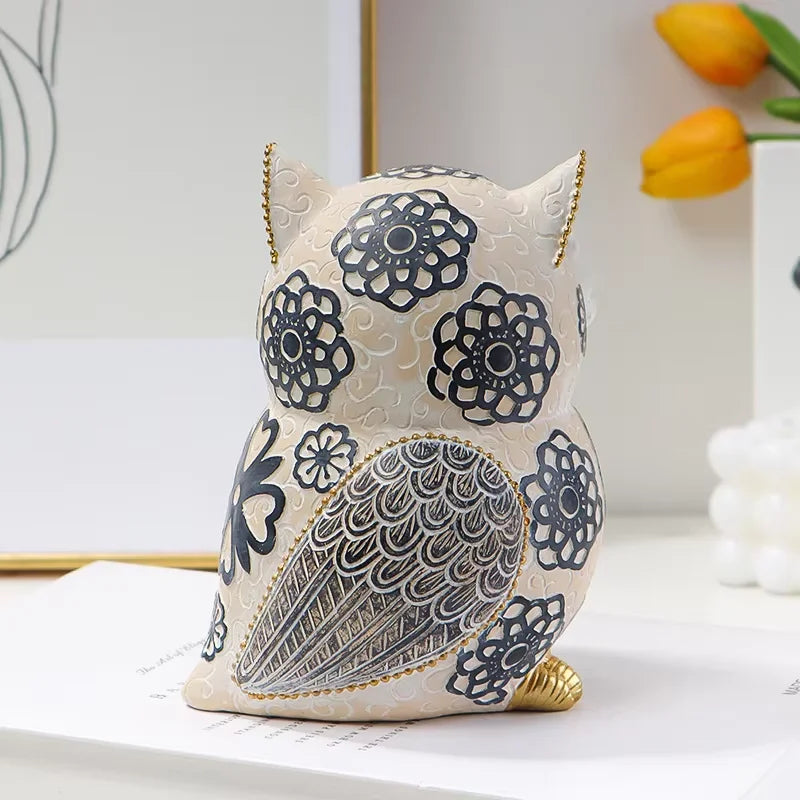 Decorative owl-shaped ornament with floral patterns on a white surface.