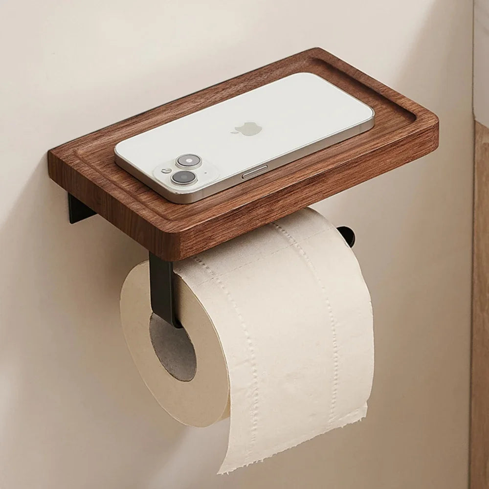 Wooden shelf with a smartphone and toilet paper roll on a beige wall.