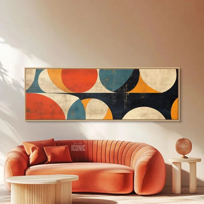 Abstract wall art above a sofa in a living room setting displayed on an terracota wall and above a modern orange sofa