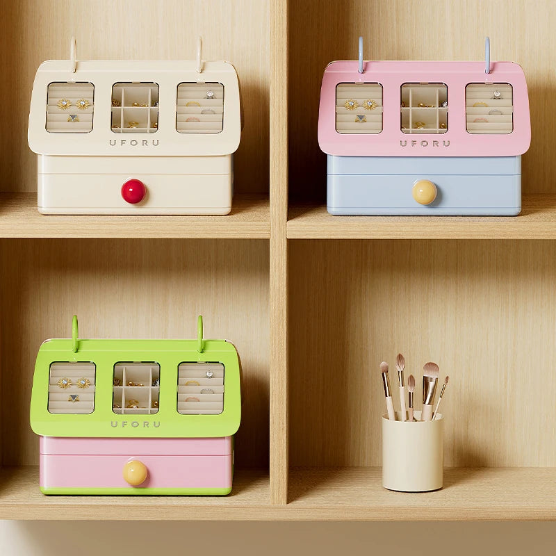 Colorful jewelry boxes on a wooden shelf with a small container of brushes.