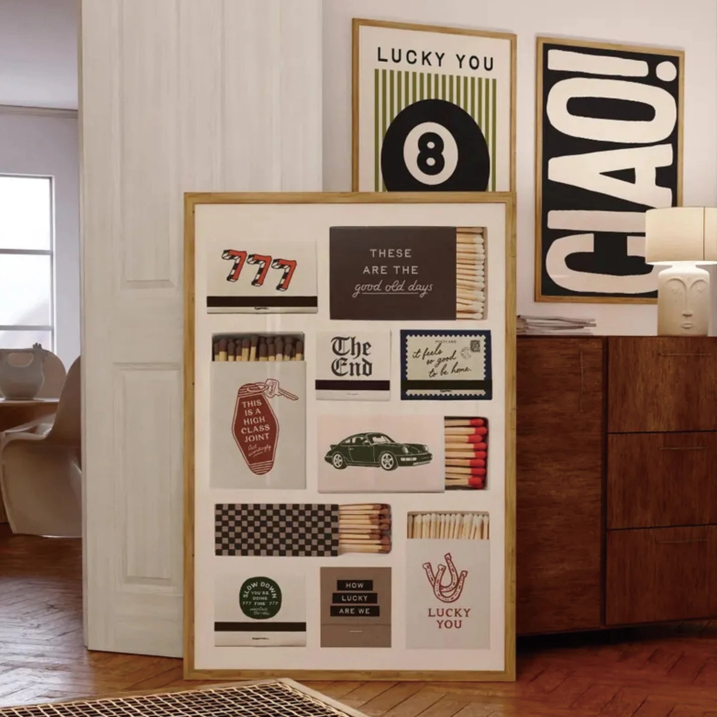 Set of three modern wall art prints featuring 8 ball, typography and graphic design displayed in a living room setting