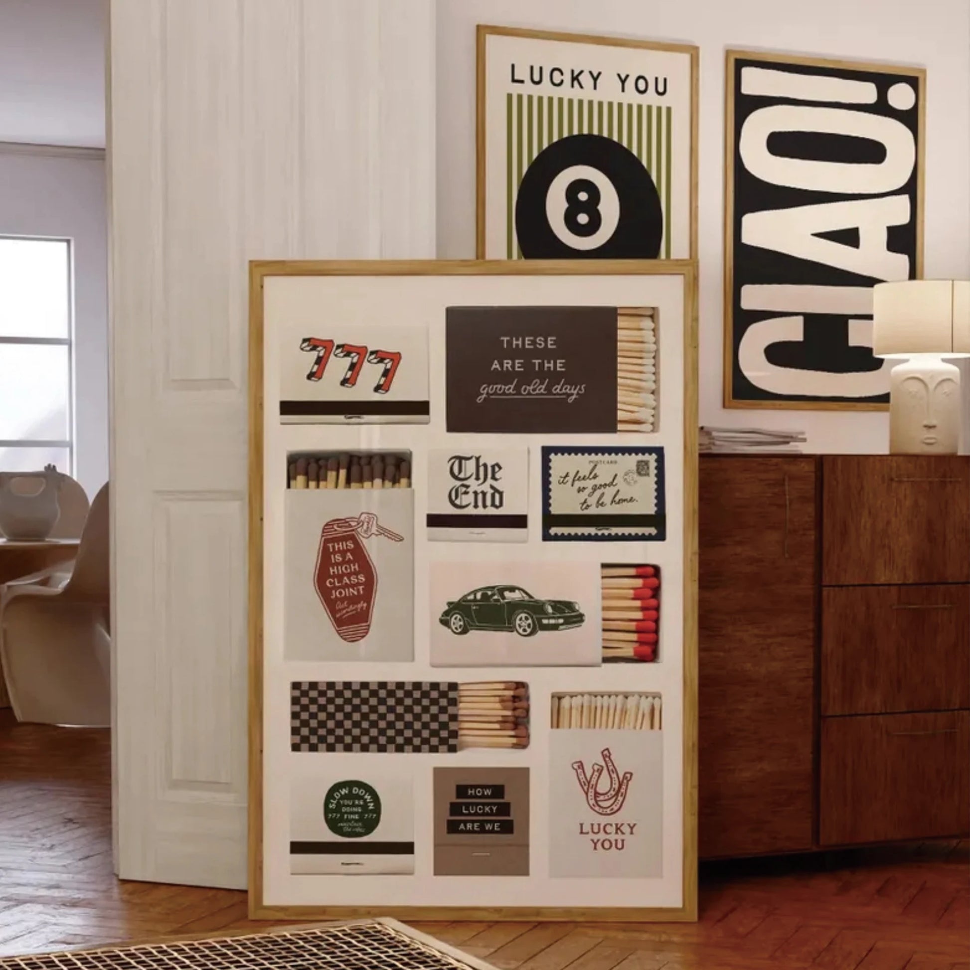 Set of three modern wall art prints featuring 8 ball, typography and graphic design displayed in a living room setting