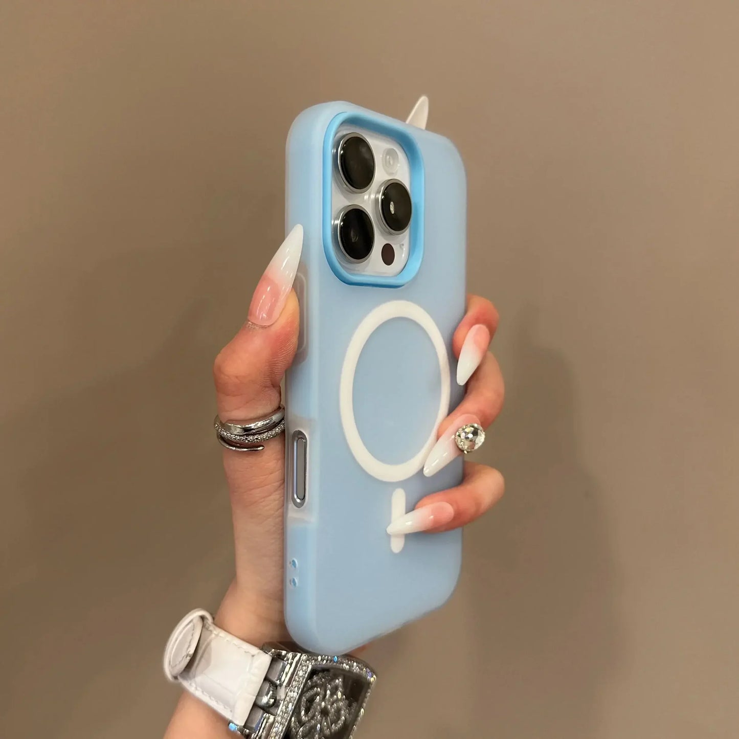Hand holding a light blue phone case with a brand logo against a beige background