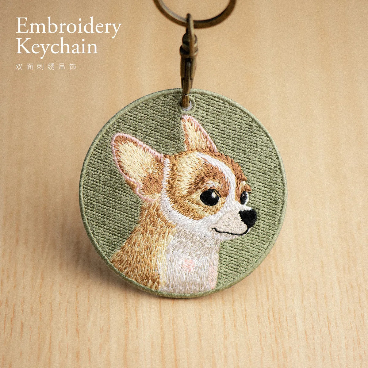 Embroidered keychain with a dog design on a wooden surface