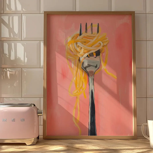 Spaghetti fork canvas print with golden pasta against a pink background, shown in a wooden frame on a kitchen worktop.