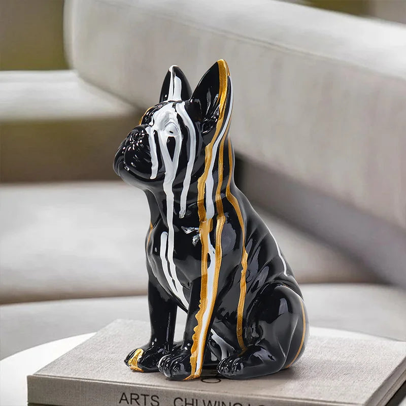 Black and gold ceramic dog figurine on a book with a blurred background