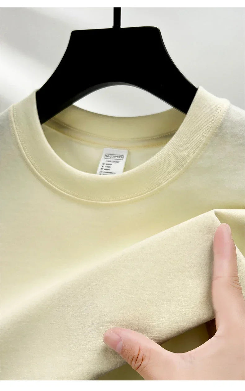 Beige sweater on a hanger with a hand touching the fabric