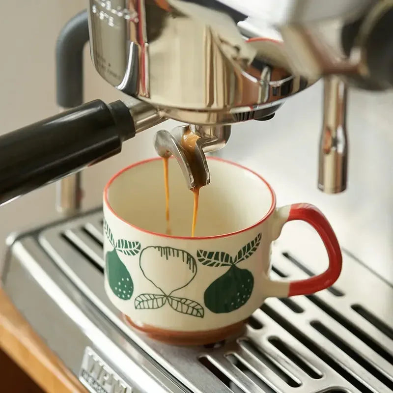 Espresso being poured into a decorative mug from an espresso machine.