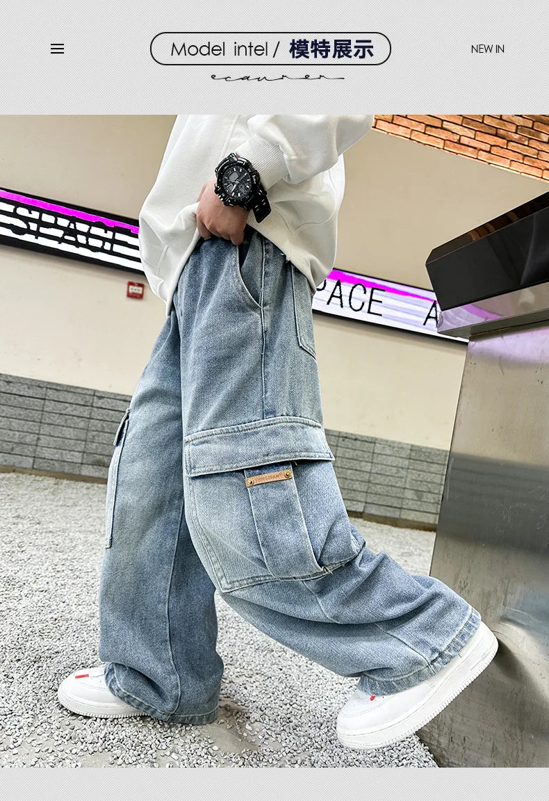 Person wearing a white hoodie and blue jeans standing in an urban setting.