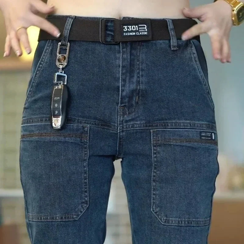 Person wearing blue jeans with a key attached to the belt loop, blurred indoor background