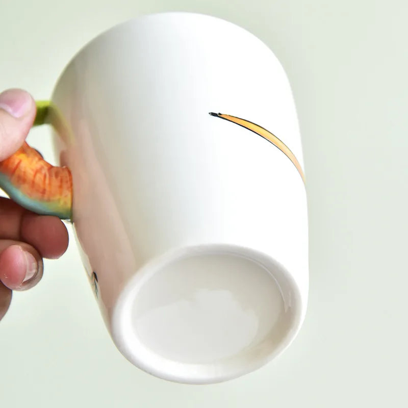 White mug with a colorful handle held by a hand on a light background