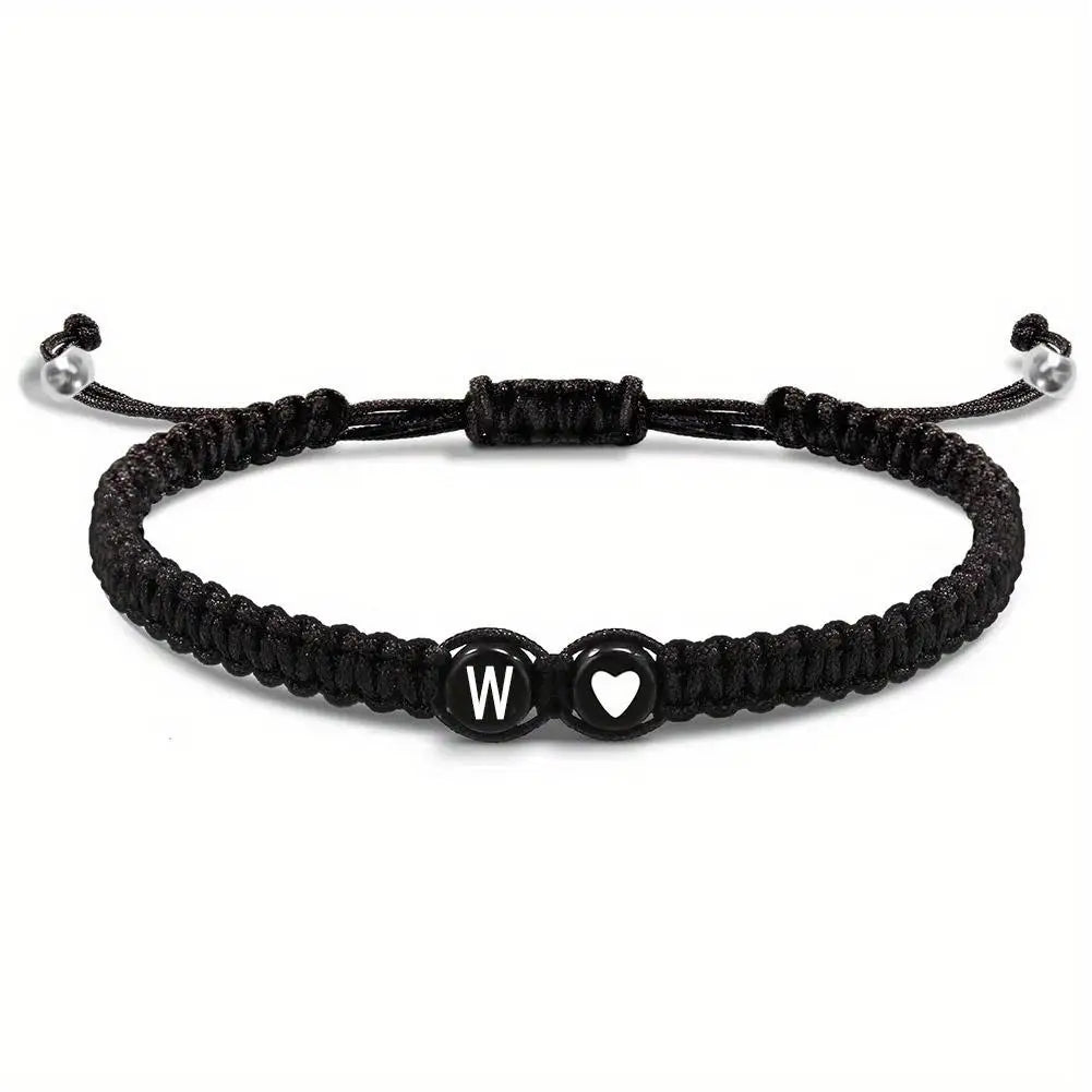 Black braided bracelet with letter 'W' and heart charm on a white background
