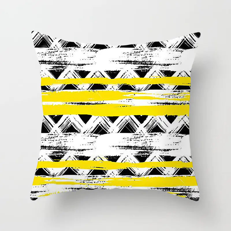 Decorative pillow with black and white geometric pattern and yellow stripes on a light gray background