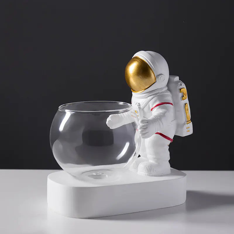 Astronaut figurine holding a glass bowl on a black background