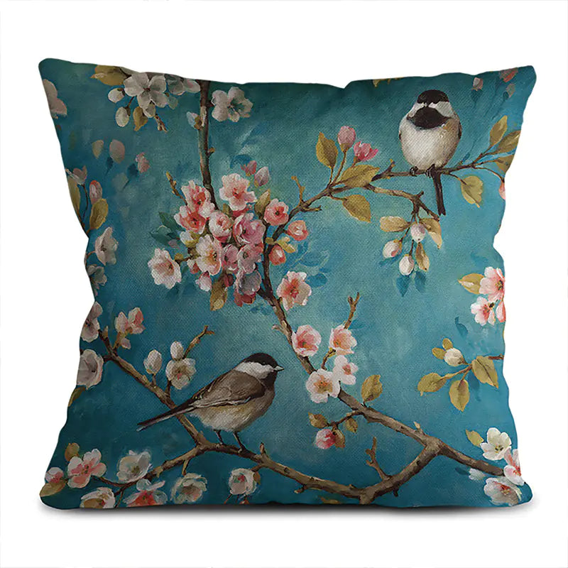 Decorative pillow with floral and bird design on a blue background