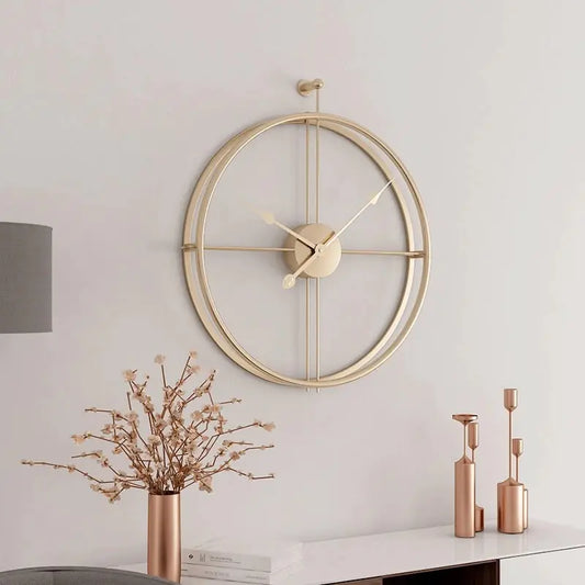 Gold wall clock on a white wall with decorative elements below.