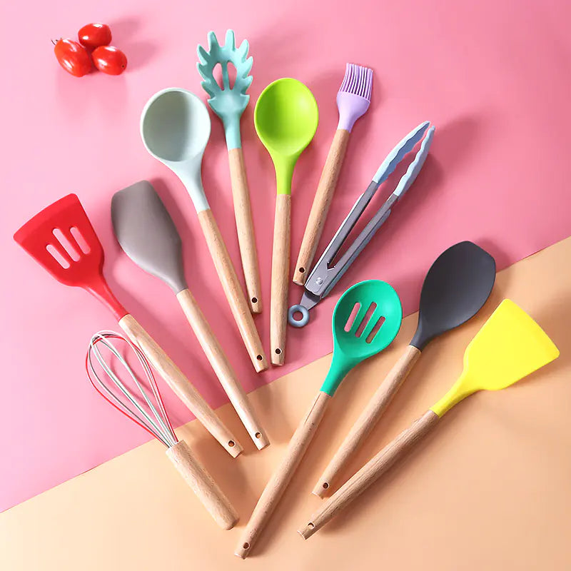 Colorful kitchen utensils on a pink and beige background