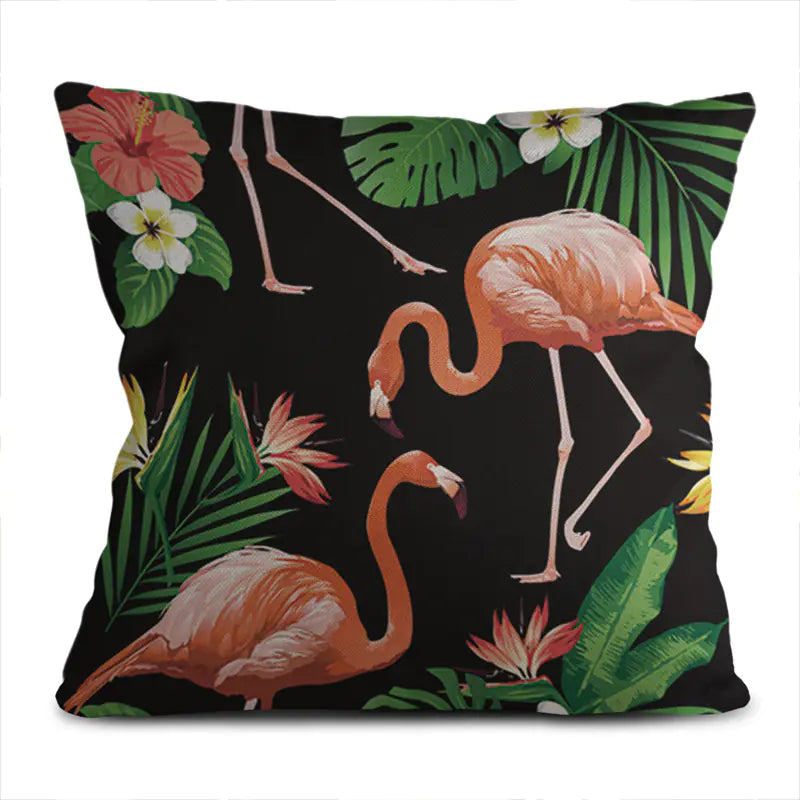 Decorative pillow with flamingo and tropical leaf design on a black background